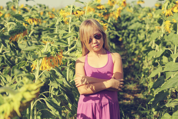Life after coronavirus. Portrait of cute girl ienjoying of freedom in the sunflowers field