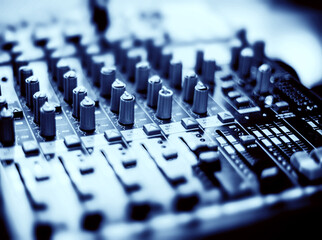 DJ mixer desk in blue tone. Tilt-shift lens use.