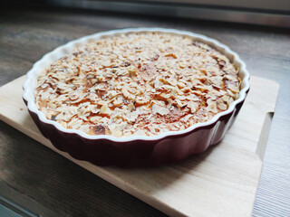 Fresh baked golden apple pie in red dish in oven at kitchen