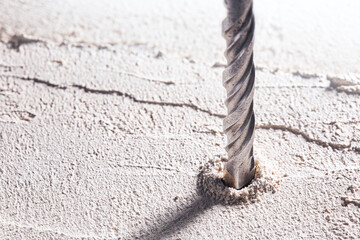 metal drill bit make holes in concrete wall on industrial drilling machine with shavings. Metal...
