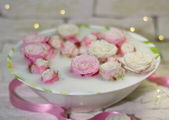 Plate with pink roses in milk water