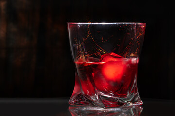 Stylish tumbler with brandy and ice cubes