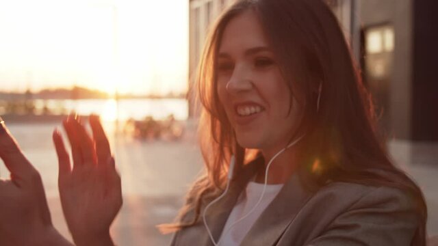 Young attractive business woman sitting outdoor on the bench. Sunset light.