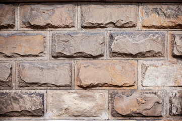Stone wall made of large stones, solid ancient foundation of the first floor, beautiful stone background