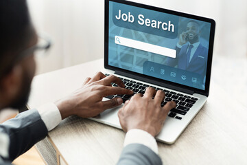 Black man using laptop with job search engine on screen
