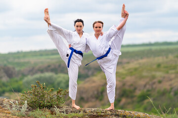 Two young woman doing a synchronised workout