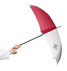 Person wehrt sich mit einem Regenschirm in den Händen und der Flagge von Malta, ein Mitgliedsstaat...