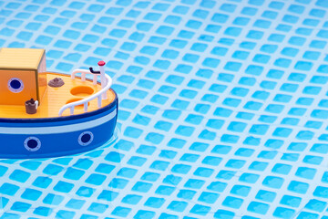 Obraz premium street lighting. children's boat with pirate flags floating on the water. Close-up