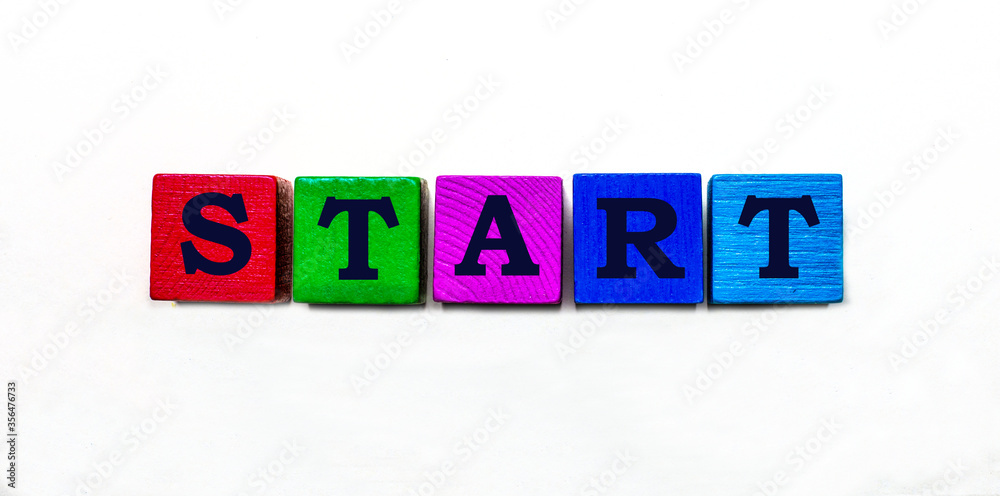 Wall mural the word start is written on colored wooden blocks. light background