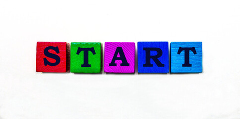 The word START is written on colored wooden blocks. Light background