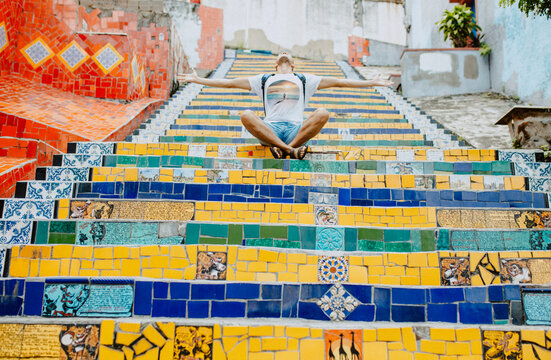Turist sit on the colors stairs. View from the bottom of the stairs Selaron, one of the most visited places in Rio de Janeiro.  multi-colored tiles from more than 60 countries