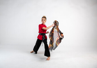 Fototapeta na wymiar beautiful girl in black and red dancing with a combat scarf