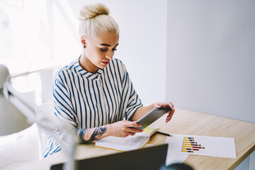 Young woman making transaction money online on tablet sitting in office