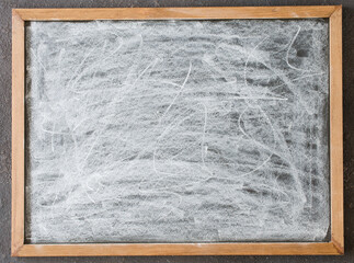 Blank chalkboard stained with chalk in wooden frame.