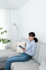ソファに座って本を読んでいる女性