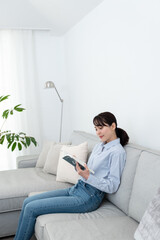 ソファに座って本を読んでいる女性
