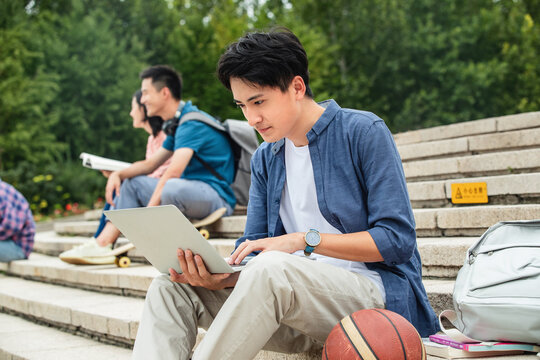 Happy college students sat on the steps of learning