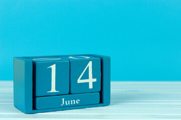 wooden calendar with the date of June 14 on a blue wooden background, World Knitting Day, World Blood Donor Day