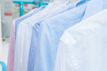 Rack with clean shirts on hangers after dry-cleaning indoors