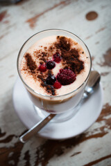 Tiramisu, traditional Italian dessert in glass on a table
