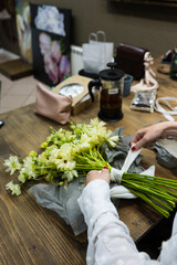 florist girl is making  a bouquet and ties it with lace ribbon