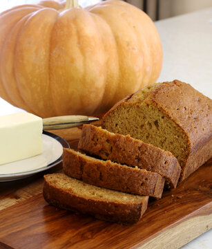 Sliced homemade pumpkin bread with butter