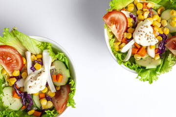 Fresh lettuce salad with tomatoes, red onion, corn, carrots, cucumber