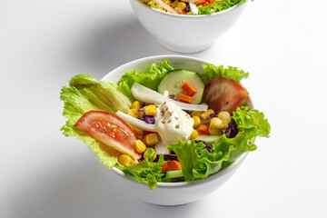 Fresh lettuce salad with tomatoes, red onion, corn, carrots, cucumber