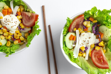 Fresh lettuce salad with tomatoes, red onion, corn, carrots, cucumber
