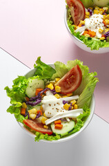 Fresh lettuce salad with tomatoes, red onion, corn, carrots, cucumber