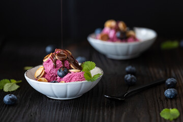 A bowl of purple icecream on a wooden table