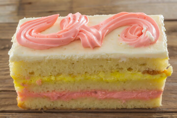 A close-up of a fresh cream cake is pictured. On top of the pattern of pink