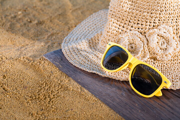 Hat and glasses lie on the sea beach. Sunny coast on a sunny morning.