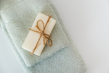 Solid soap corded on bath towels on white background with copy space. Top view with copy space