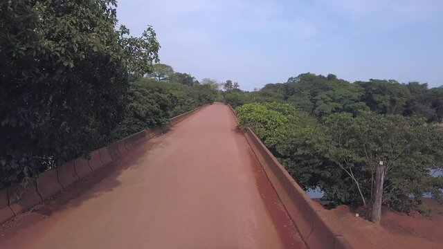 Drone aerial view of dirt road bridge over Teles Pires river in the Amazon rainforest, Mato Grosso, Brazil. Concept of travel, transport forest, nature, environment, ecology and logistics. 4K