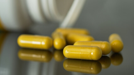 yellow pills on a reflective surface
