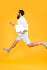 Fototapeta na wymiar Mobile is lifestyle not technology. Energetic hipster in midair yellow background. Bearded man run with laptop. Mobile use. Mobile device. Mobile internet access. 3G or 4G connectivity. Modern life