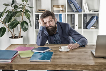 time to sleep. early morning drink. modern office life. mature businessman at workplace. exhausted and overworked. ceo nap at table with notebook and laptop. tired man drink coffee. need more energy