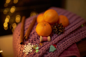 Photo for the New Year card. New Year's composition. View from above. Warm knitted scarf in purple. Tangerines lie on a scarf. Christmas composition with tangerines and a scarf.