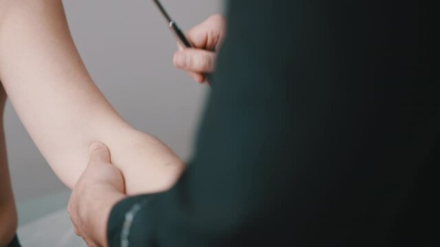 The neurologist checks the reflex of the patient's hand. Slow motion.