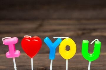 candles letters i love you on dark wooden background
