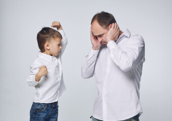 Fototapeta premium the little son dominates the father. fatherhood, psychology of relationships.Studio, White background