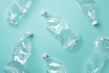 Plastic empty rumpled bottles on a blue background. Top view, copy space. Zero waste. Pollution,...
