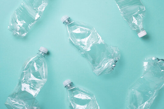 Plastic empty rumpled bottles on a blue background. Top view, copy space. Zero waste. Pollution, environmental protection concept. Reuse garbage, recycle, plastic free. Earth, world water day