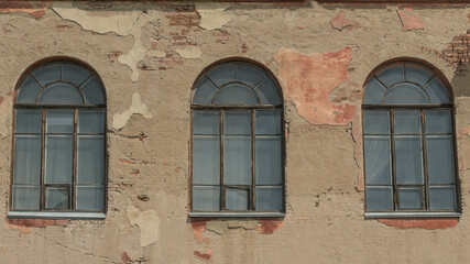 Fototapeta na wymiar Three old arched windows of a building