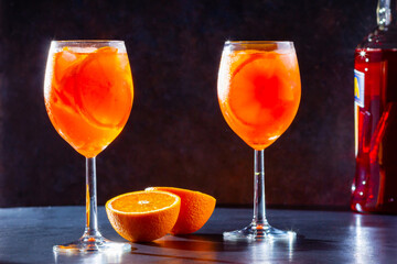 Aperol spritz cocktail on dark background. Two glasses of aperol spritz with orange slised. Summer cocktail in glass. Copy space