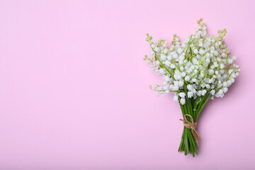 Beautiful lily of the valley flowers on pink background, top view. Space for text