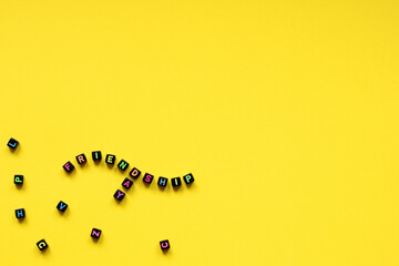 The word friendshipday composed from cubes with multicolored letters on a yellow background. A close-up.