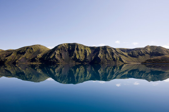 reflection of mountain range in still lake on the Icelandic highlands
