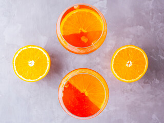 Aperol spritz cocktail on a gray background. Two glasses of aperol spritz with orange slised. Summer cocktail in glass. Top view. Copy space